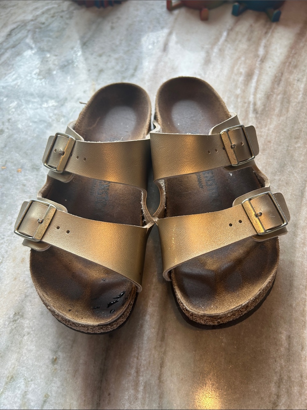 Birkenstock Arizona-style slides in metallic gold, size 36.